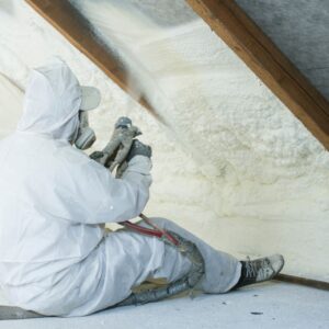 a professional installing spray foam insulation in an attic