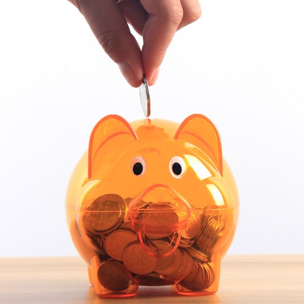 Someone placing money into a piggy bank